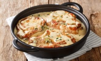 Baked pork chops covered in creamy sauce with herbs.