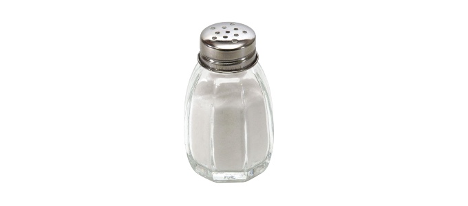 A clear glass salt shaker with a shiny metal top