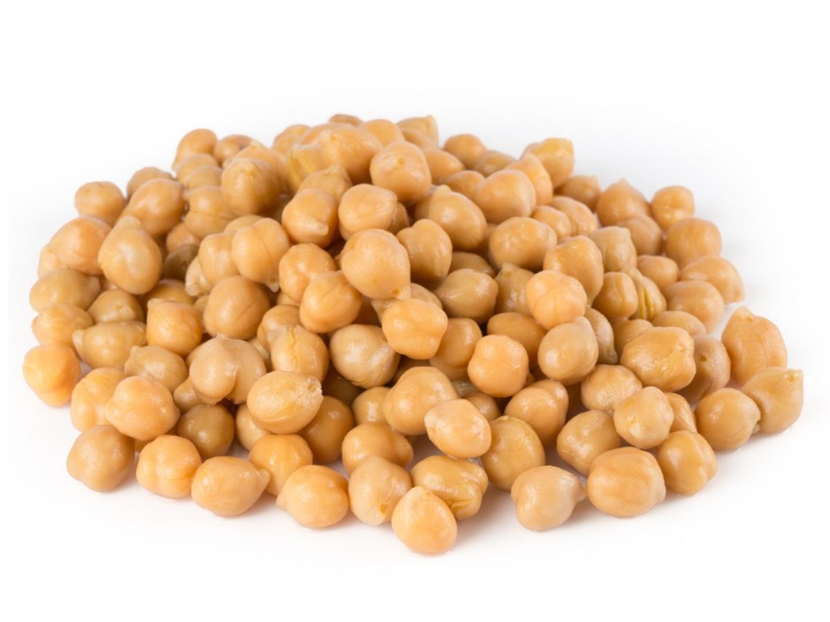 Pile of cooked chickpeas on a white background.