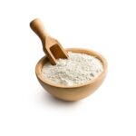 Baking powder in a wooden bowl with a wooden spoon