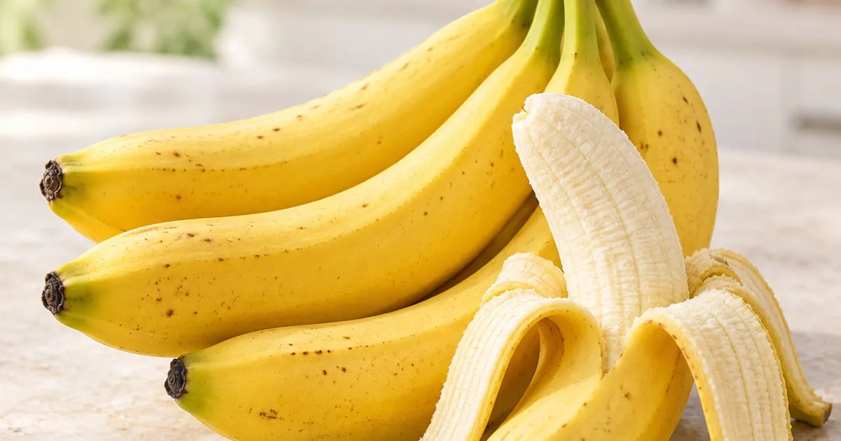 Ripe yellow bananas with one partially peeled banana