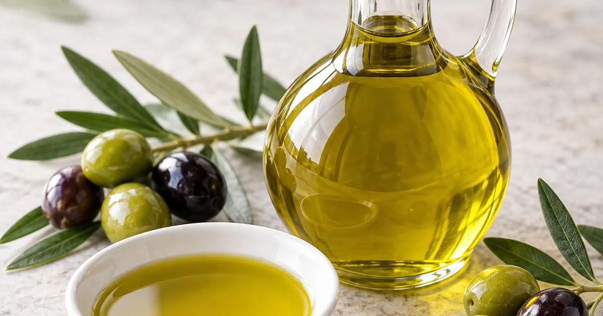 Extra virgin olive oil with fresh olives and olive leaves