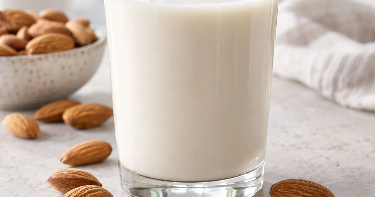 Glass of fresh almond milk with almonds