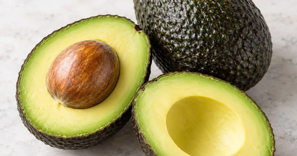 Fresh ripe Hass avocados, whole and cut in half