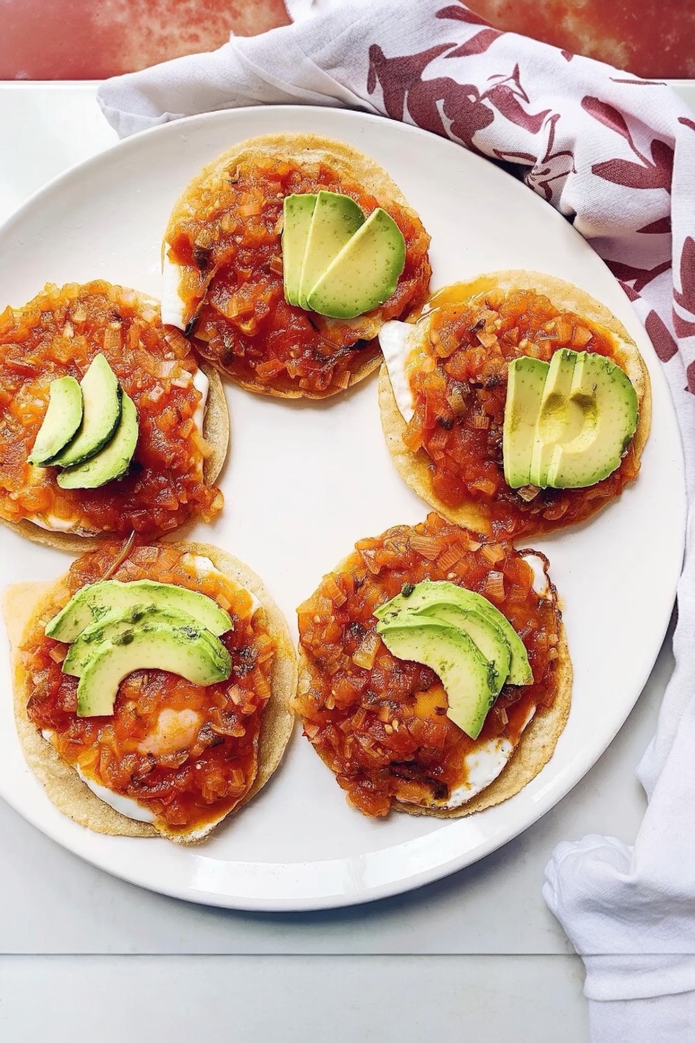 Huevos Rancheros served on corn tortillas with eggs, salsa, and avocado slices